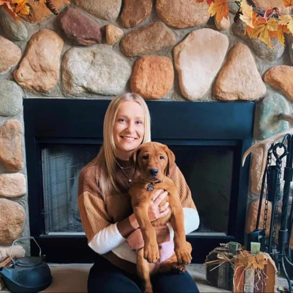 Red lab and owner in front of fireplace